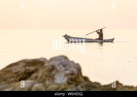 Einbaum fischer Silhouette gegen Orange Sonnenaufgang am Lake Malawi, die Sonne Glitzern auf dem See, Süd-Ost-Afrika Stockfoto