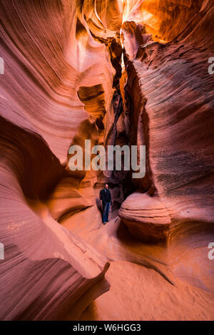 Mann in einem Slot Canyon bekannt als Canyon X, in der Nähe von Page, Arizona, Vereinigte Staaten von Amerika Stockfoto