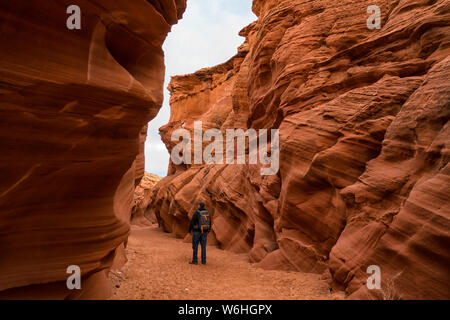 Man Walking in Slot Canyon bekannt als Eule Canyon, in der Nähe von Page, Arizona, Vereinigte Staaten von Amerika Stockfoto