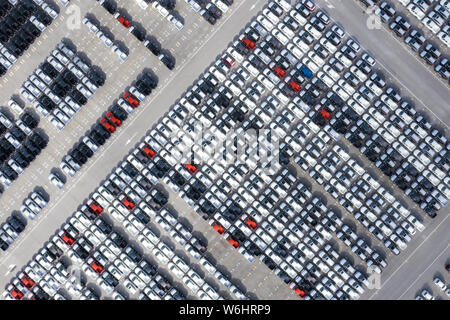 Antenne Top View neue Autos bis in den Hafen für import export Business Logistik und Transport per Schiff auf dem offenen Meer gesäumt. Neue Autos aus dem Auto fa Stockfoto