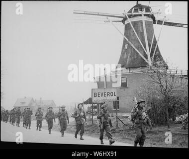 Infanterie der Regiment de Maisonneuve bewegen durch Holten Rijssen, beide Städte in den Niederlanden. 9. April 1945. New York Times Paris Bureau Sammlung.; Allgemeine Hinweise: Verwenden Sie Krieg und Konflikt Nummer 1081 bei der Bestellung eine Reproduktion oder Anforderung von Informationen zu diesem Bild. Dieses Bild ist Teil der New York Times Paris Bureau Sammlung. Stockfoto