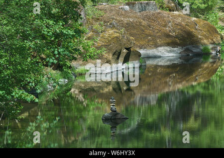 Oder: Douglas Co., Cascades. Wasser Reflexionen im Süden Umpqua River, in einem immer noch Abschnitt von Felsen gesäumt, zeigen eine meditative Rock Stapel Stockfoto