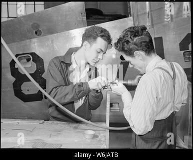 Los Angeles, Kalifornien. Flugzeuge Schulen. Zwei Jungen, die Arbeit an einem Nieten Sampler als ein Problem, auf dem Sie benotet wird. Nieten ist in Flugzeuge Ausbildung betont, und ein Monat der Jungen 'zwei Monat Kurse in es üben ausgegeben werden. Die Arbeit erfordert viel Geschick und Genauigkeit bei der Verwendung der kleinen Druckluft Nietzange hier gezeigt Stockfoto