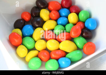 Farbenprächtigen hart peanut Schokolade Bonbons in einer weißen Schüssel, in den Farben Rot, Grün, Blau und Braun Stockfoto
