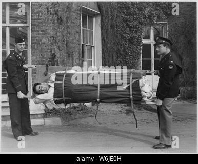 Großen Milton Erdel (links), und Lieutenant J. H. Shuford, zeigen, dass es unmöglich ist, für einen Patienten fallen aus die Ausdehnung. Der Ersatz patient Sergeant. Charles Malianni. Bushey Park, London, England; Allgemeine Hinweise: Verwenden Sie Krieg und Konflikt Nummer 906 bei der Bestellung eine Reproduktion oder Anforderung von Informationen zu diesem Bild. Stockfoto