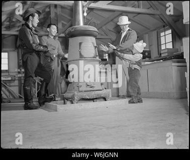 Minidoka Relocation Center. Community Shop Block 30. Kunden Erwärmung der Hände durch Herd. Stockfoto