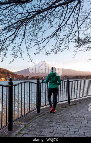 Atmosphäre am Abend, junge Frau, die auf der Promenade, mit Blick auf Lake Kawaguchi, zurück Vulkan Mt. Fuji, Yamanashi Präfektur, Japan Stockfoto