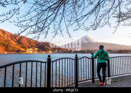 Atmosphäre am Abend, junge Frau, die auf der Promenade, mit Blick auf Lake Kawaguchi, zurück Vulkan Mt. Fuji, Yamanashi Präfektur, Japan Stockfoto