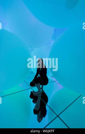 Junge Frau, Große beleuchtete Kugeln, LED-Installation in der Digitalen Kunst Museum, TeamLab Planeten, Koto City, Tokio, Japan Stockfoto