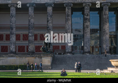 BERLIN, DEUTSCHLAND - 28. Juli 2018: Mann sitzt vor dem Alten Museum, seine jonic Säulen und antiken Statuen, und seine vorderen Lustgarten an der Stockfoto