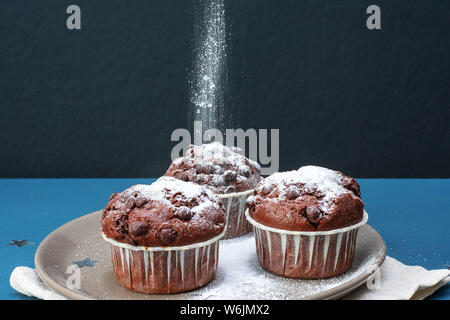 Pulver Zucker auf drei chocolate Cupcakes. Feier. Geburtstag. Weihnachten und neues Jahr. Stockfoto