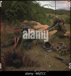 Betrieb Oregon, ein Suchen und Mission durch einen infanteriezug von Truppe B durchgeführt, 1 Reconnaissance Squadron, 9th Cavalry, 1st Cavalry Division (Airmobile), drei Kilometer westlich von Duc Pho, in der Provinz von Quang Ngai zerstören. Ein infanterist ist in einen Tunnel, die von Mitgliedern der Reconnaissance Platoon abgesenkt. Stockfoto