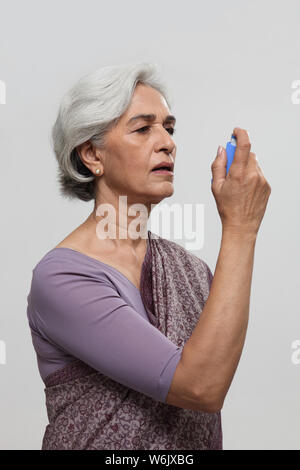 Alte Frau mit Asthma-Inhalator Stockfoto