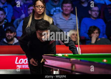 Ding Junhui von China hält einen Schuß zu Mark Selby von England in ihrem Halbfinale während der 2018 Ladbrokes World Grand Prix snooker Turnier Stockfoto