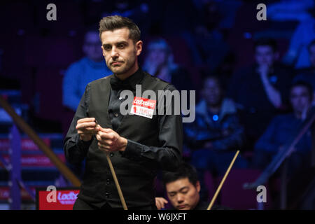 Mark Selby von England hält einen Schuß zu Ding Junhui von China in ihrem Halbfinale während der 2018 Ladbrokes World Grand Prix snooker Turnier Stockfoto