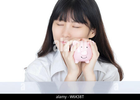 Weibliche putting Amicana Münzen und ein Viertel in ein Sparschwein auf weißem Hintergrund Stockfoto