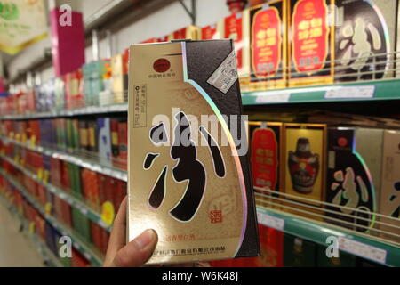 --FILE - ein chinesischer Kunde Geschäfte für eine Flasche Fen Jiu Likör von Shanxi Xinghuacun Fen Wein Factory Co., Ltd. in einem Supermarkt in der Stadt Rizhao, Nord Stockfoto