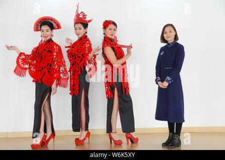 36-jährige Chinesische Handwerker Liang Ying, rechts, ein Erbe der Papier-Stecklinge, Posen für Fotos mit Modelle tragen Kopf Zubehör, Capes, und Ohr Stockfoto