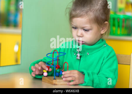 Kinder spielen mit Raupe Labyrinth Spielzeug im Kindergarten Stockfoto