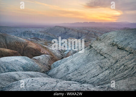 Bizarr übereinander geschichteten Berge und Schluchten bei Sonnenuntergang in der Wüste park Altyn Emel in Kasachstan Stockfoto