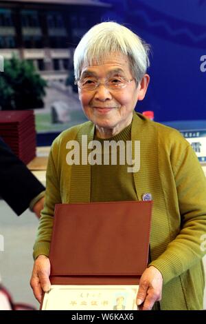 Der 81-jährige Chinesische student Xue Minxiu stellt mit ihrer grundständigen Diplom der Tianjin University, die Sie in Richtung für Jahre gearbeitet hatte, in Tia Stockfoto