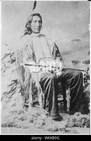 Red Cloud (Maqpeya - luta), Chef der Oglala Sioux; in voller Länge, Sitz, holding Zuckerrohr Stockfoto