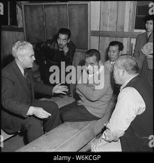 Rohwer Relocation Center, McGehee, Arkansas. Doktor S. A. Weber, vom War Relocation Authority. . .; Umfang und Inhalt: Der vollständige Titel für dieses Foto lautet: Rohwer Relocation Center, McGehee, Arkansas. Doktor S. A. Weber, aus dem Krieg Umzug Behörde Büro in Salt Lake City, der fliessend Japanisch spricht, spricht mit einigen der Evakuierten während des Besuchs einer Verlagerung der Rohwer Projekt. Stockfoto