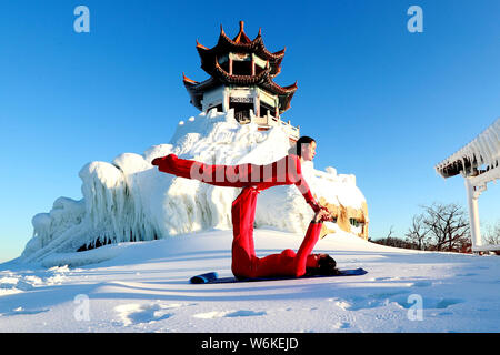 Chinesische Mädchen das Tragen der roten Yoga Kleidung yoga führen Sie vor Kälte an einem Ski Park in Luanchuan County, Luoyang City, Central China Provinz Henan, 11 J Stockfoto