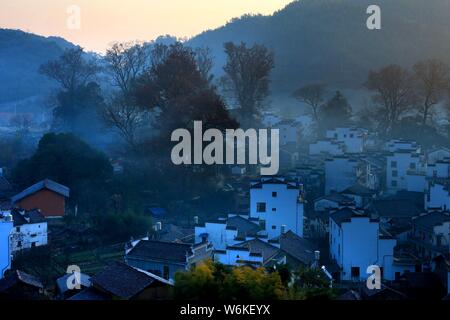 Winterlandschaft von alten Häusern mit Mau Tou Wand (Pferdekopf an der Wand) mit Rauch von Küche, Schornsteine in Wuyuan County, Stadt Shangrao, East China Ji Stockfoto