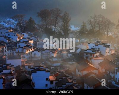 Winterlandschaft von alten Häusern mit Mau Tou Wand (Pferdekopf an der Wand) mit Rauch von Küche, Schornsteine in Wuyuan County, Stadt Shangrao, East China Ji Stockfoto