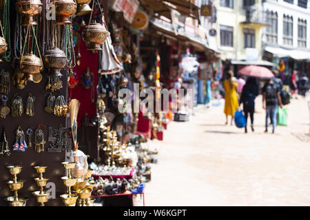 (Selektive Fokus) Blick auf einige Souvenirs (Klangschalen, Hand geschaffenen Statuen und Rudraksha Halskette) auf einem Straßenmarkt in Kathmandu. Stockfoto