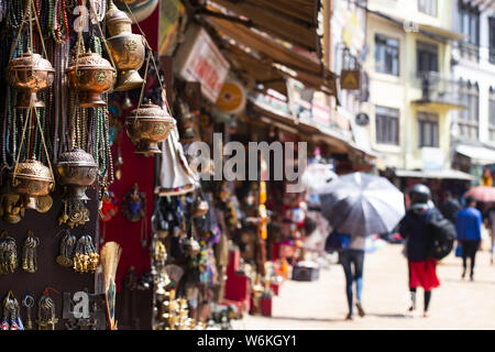 (Selektive Fokus) Blick auf einige Souvenirs (Klangschalen, Hand geschaffenen Statuen und Rudraksha Halskette) auf einem Straßenmarkt in Kathmandu. Stockfoto