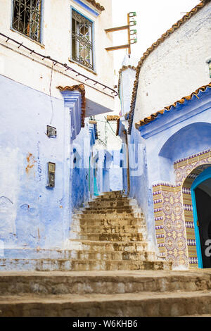 Atemberaubende Aussicht auf eine schmale Gasse mit den auffälligen, blau getünchten Gebäuden. Chefchaouen, oder Chaouen, ist eine Stadt im Rif-gebirge in Marokko. Stockfoto