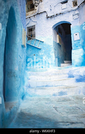 Atemberaubende Aussicht auf eine schmale Gasse mit den auffälligen, blau getünchten Gebäuden. Chefchaouen, oder Chaouen, ist eine Stadt im Rif-gebirge in Marokko. Stockfoto