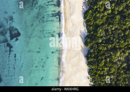 Ansicht von oben, atemberaubenden Blick auf eine erstaunliche wilden Strand durch eine transparente und das türkisfarbene Meer gebadet. Sardinien, Italien. Stockfoto