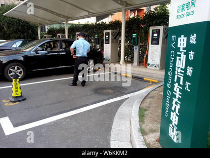 ---- Ein Elektrofahrzeug (EV) wird an eine Ladestation von State Grid Corporation von China in Shanghai, China, 1. September 2017 aufgeladen. B Stockfoto