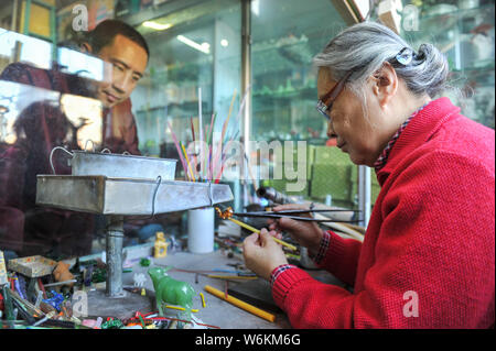 ------ Chinesische Liuli Handwerk master Xing Lanxiang macht einen Liuli Artwork, eine Uralte Art der chinesischen Glas, in ihrem Studio in Peking, China, 22. Dez. Stockfoto