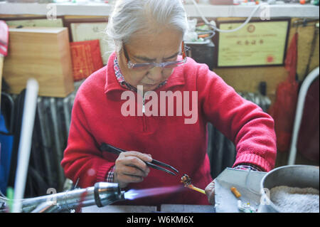 ------ Chinesische Liuli Handwerk master Xing Lanxiang macht einen Liuli Artwork, eine Uralte Art der chinesischen Glas, in ihrem Studio in Peking, China, 22. Dez. Stockfoto