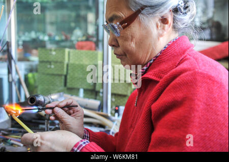 ------ Chinesische Liuli Handwerk master Xing Lanxiang macht einen Liuli Artwork, eine Uralte Art der chinesischen Glas, in ihrem Studio in Peking, China, 22. Dez. Stockfoto