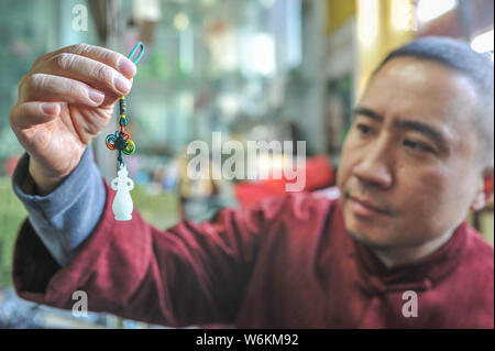 ----, Der Sohn des Chinesische Liuli Handwerk master Xing Lanxiang zeigt eine Liuli Artwork, eine Uralte Art der chinesischen Glas, in ihrem Studio in Peking, Ch Stockfoto