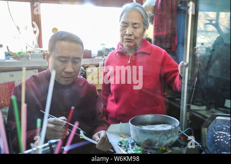 ------ Chinesische Liuli Handwerk master Xing Lanxiang, Recht, Uhren, ihrem Sohn eine Liuli Artwork, eine Uralte Art der chinesischen Glas, an ihr Studio Stockfoto