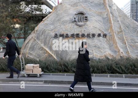 ---- Fußgänger vorbei an den Hauptsitz der Asiatischen Infrastruktur Investitionsbank (AIIB) in Peking, China, 11. Dezember 2017. Die asiatische Inf Stockfoto