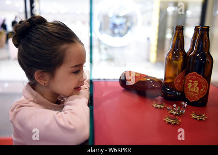 Ein kleines Mädchen sieht in der "Happy Family Reunion Dinner' durch japanische Miniatur Artist Tatsuya Tanaka während seiner mini CHOCOllection Miniatur- Stockfoto