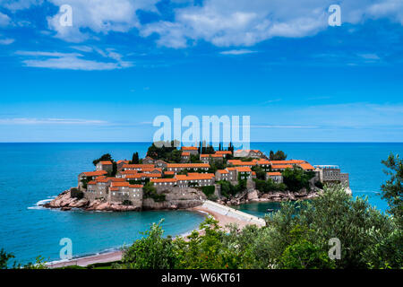 Montenegro, Blick über die felsige Insel Sveti Stefan mit alten Häusern aus Stein mit roten Dächern im Sommer Urlaub Stockfoto