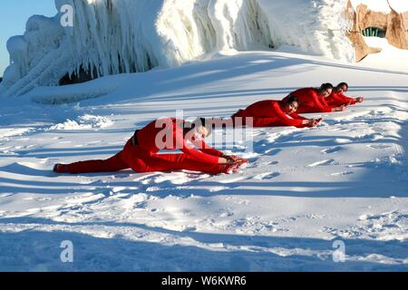 Chinesische Mädchen das Tragen der roten Yoga Kleidung yoga führen Sie vor Kälte an einem Ski Park in Luanchuan County, Luoyang City, Central China Provinz Henan, 11 J Stockfoto