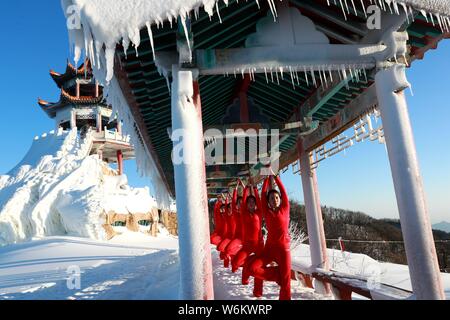 Chinesische Mädchen das Tragen der roten Yoga Kleidung yoga führen Sie vor Kälte an einem Ski Park in Luanchuan County, Luoyang City, Central China Provinz Henan, 11 J Stockfoto