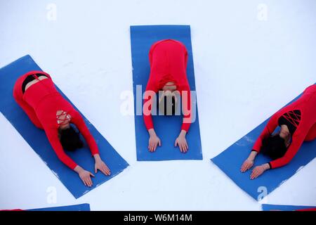 Chinesische Mädchen das Tragen der roten Yoga Kleidung yoga führen Sie vor Kälte an einem Ski Park in Luanchuan County, Luoyang City, Central China Provinz Henan, 11 J Stockfoto