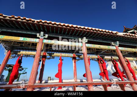 Chinesische Mädchen das Tragen der roten Yoga Kleidung yoga führen Sie vor Kälte an einem Ski Park in Luanchuan County, Luoyang City, Central China Provinz Henan, 11 J Stockfoto