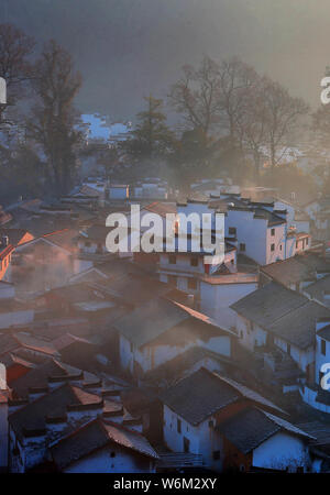 Winterlandschaft von alten Häusern mit Mau Tou Wand (Pferdekopf an der Wand) mit Rauch von Küche, Schornsteine in Wuyuan County, Stadt Shangrao, East China Ji Stockfoto