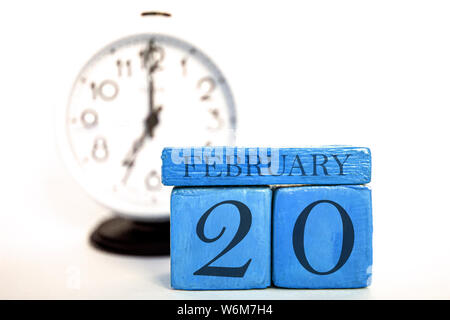 Februar 20th. 20. Tag des Monats, handgefertigten Holz Würfel Kalender und Wecker auf Blau. Winter Monat, Tag des Jahres Konzept. Stockfoto